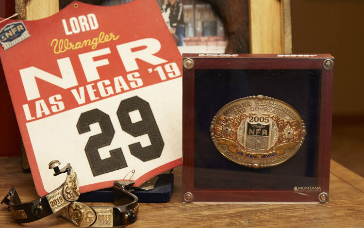 A National Finals Rodeo back number posed next to her world qualifying belt buckle and spurs for winning a round at the NFR. 